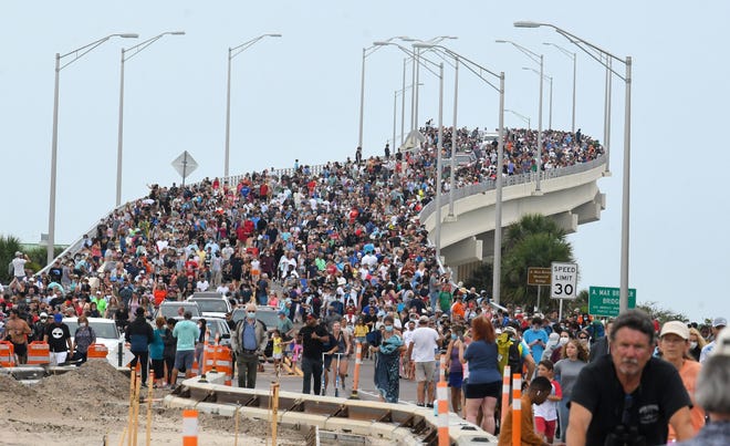 Large crowds of launch spectators on the A. Max Brewer Bridge in Titusville return to their vehicles in May 2020 after a cleanup of the historic SpaceX Demo-2 flight, the first American crewed mission in nearly a decade.